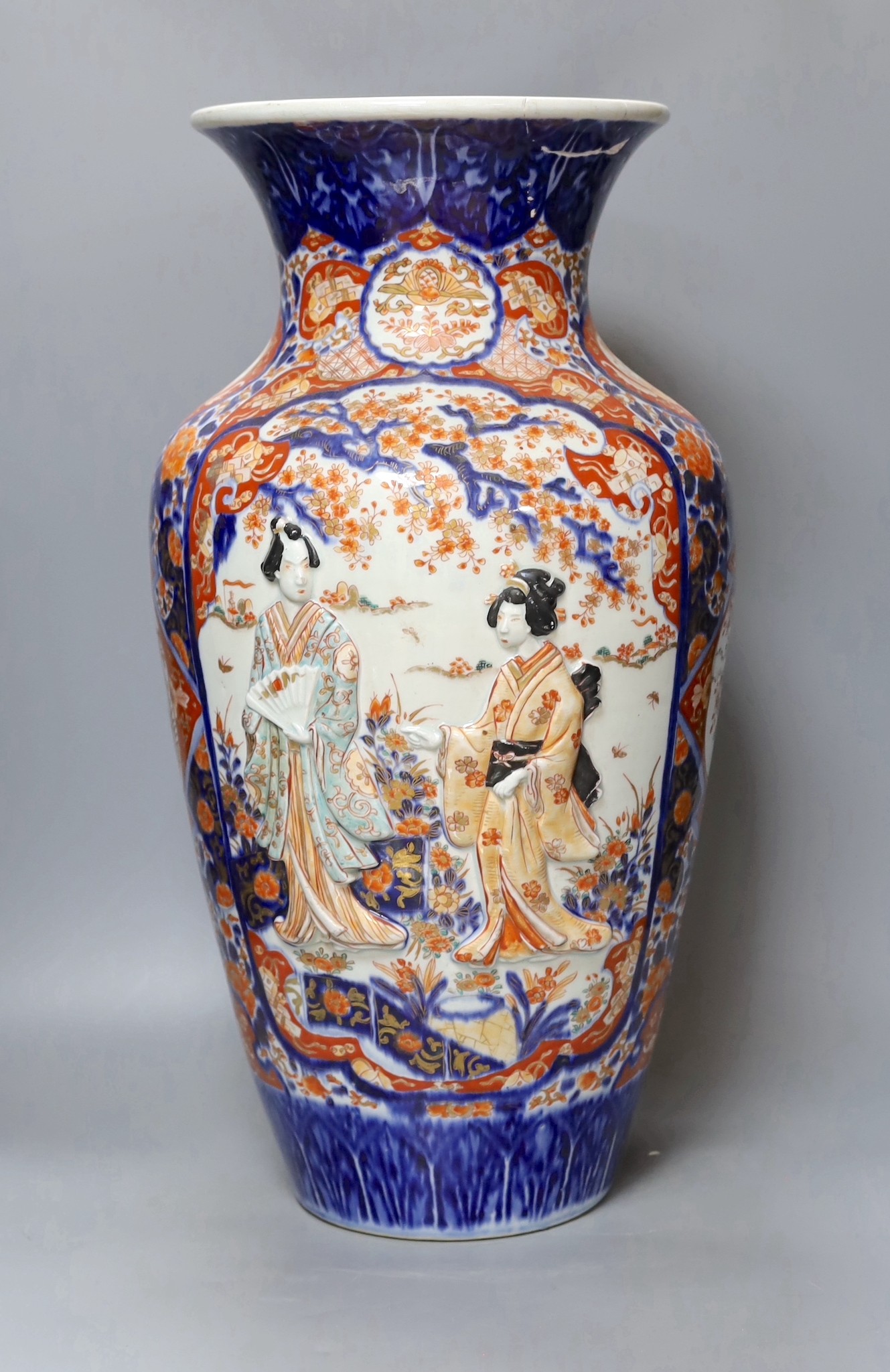 An unusual large Japanese Imari vase, Meiji period relief moulded with figures, 57cm tall, repairs